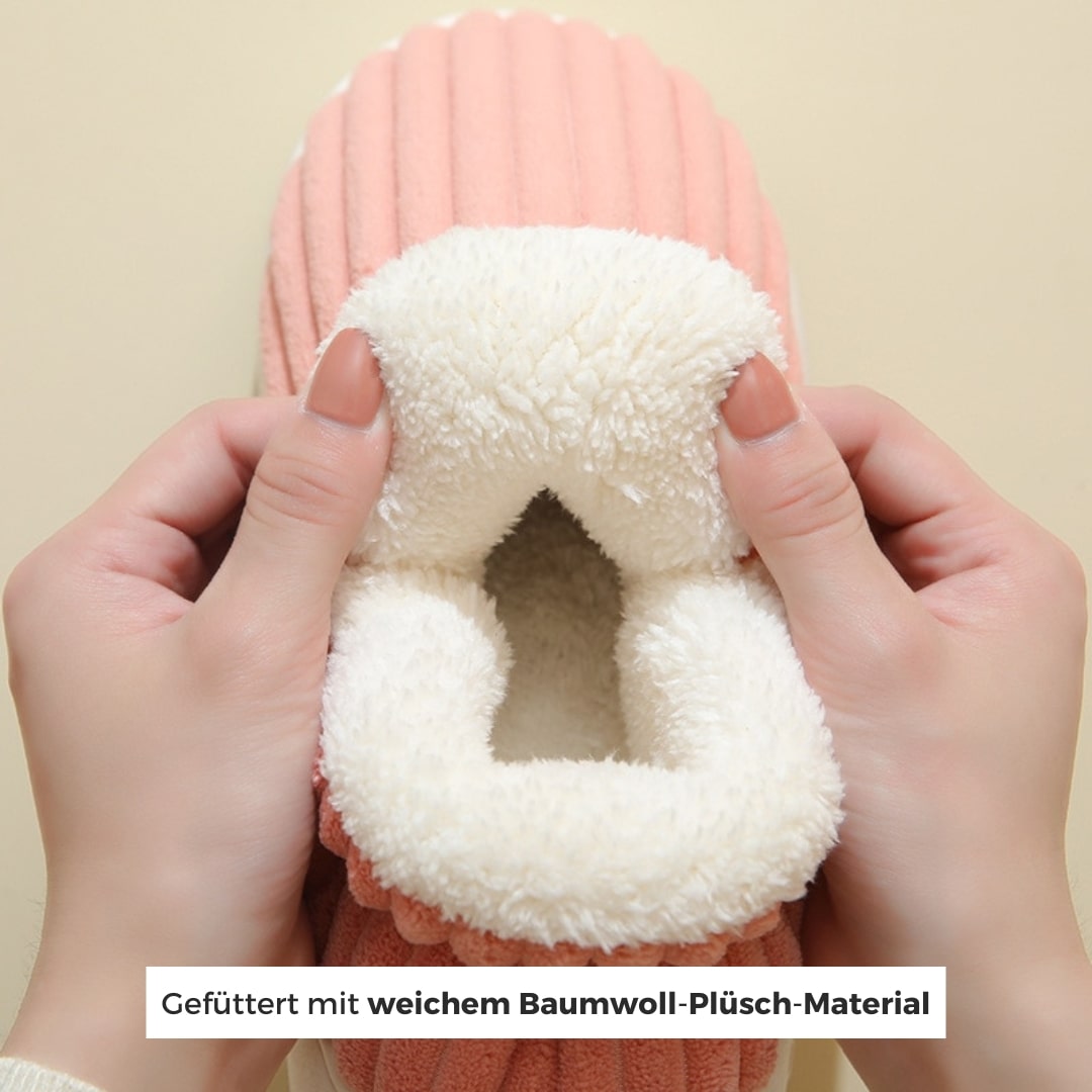 Hände, die warme pink hausschuhe vorführen